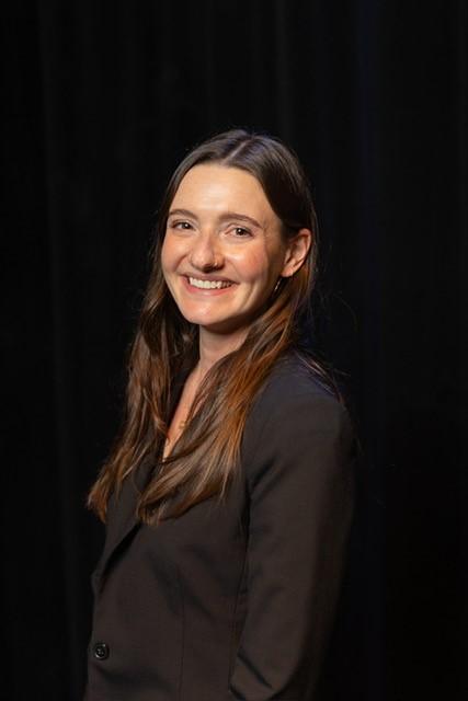 woman with dark hair smiling for a portrait